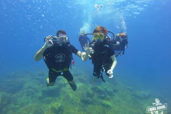 Open Water Diver student practicing underwater skills with instructor in clear tropical waters