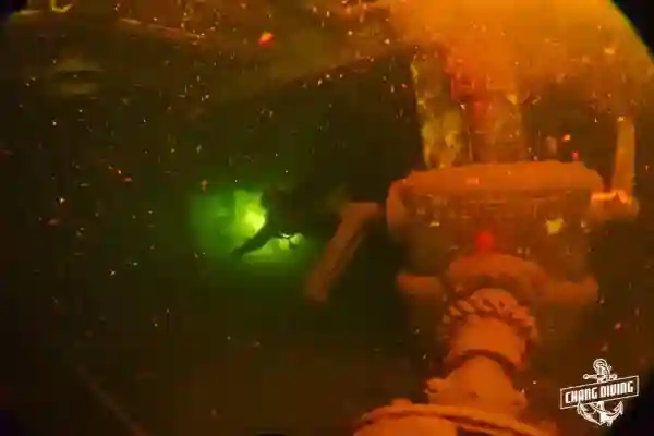 Wreck diver navigating through HTMS Chang interior passages