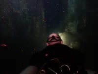 Sidemount diver inside a dark passage of the HTMS Chang wreck during an advanced wreck dive in Koh Chang